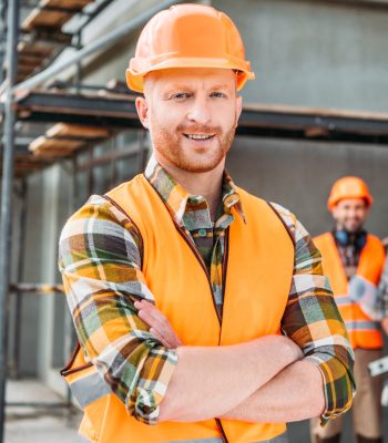 smiling-builder-standing-at-construction-site-with-2021-08-30-19-58-46-utc.jpg